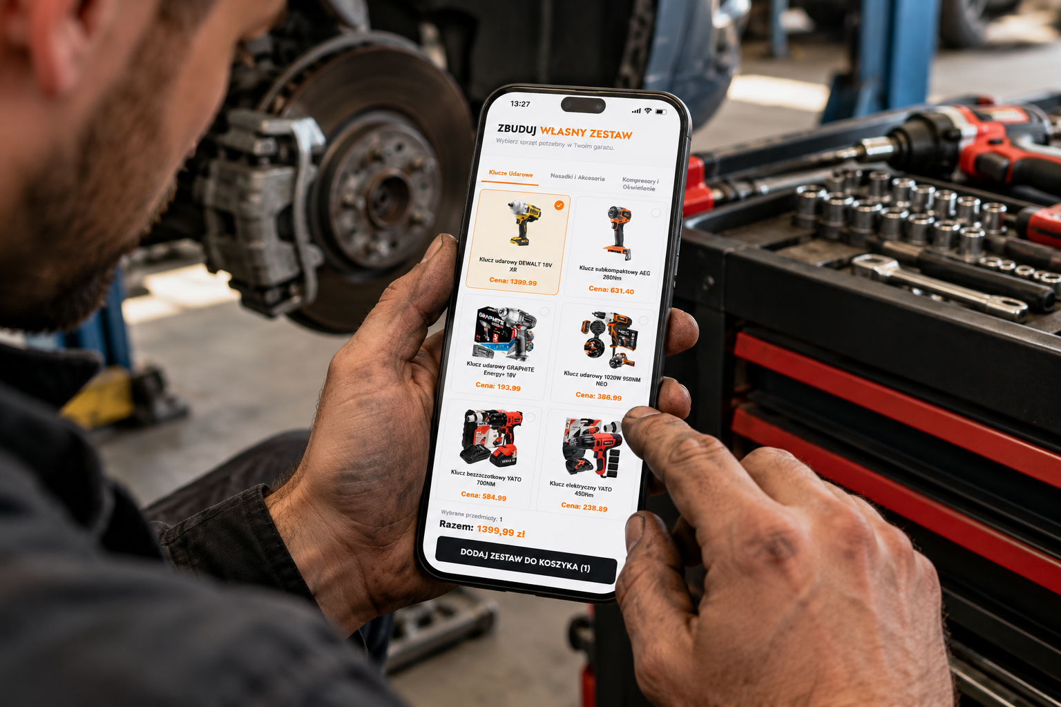 Mechanik korzystający z nowego kreatora zestaw&oacute;w na smartfonie z widocznym logiem Galeria Narzędzi